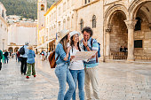 Three Young Friends Reading A Map On The Street In Dubrovnik