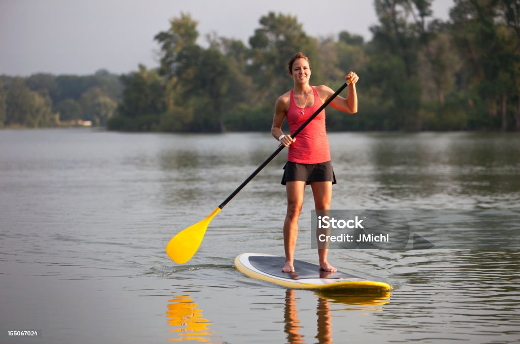 Athletic Woman Paddle Boarding on a Calm Midwestern Lake.  Paddleboarding Stock Photo