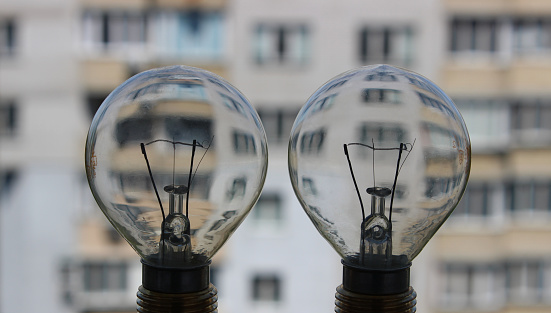 Bulb Light With Multi Storey Building On A Background As An Illustration Of Electricity Efficient