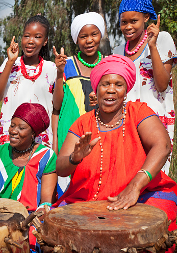 Traditional africans singing, while the two mature ladies play the drums, happy smiling and content; focus on the girls.\n[url=file_closeup.php?id=17684736][img]file_thumbview_approve.php?size=1&id=17684736[/img][/url] [url=file_closeup.php?id=17697149][img]file_thumbview_approve.php?size=1&id=17697149[/img][/url]