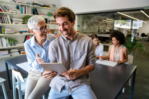 istock Smiling diverse colleagues gather in boardroom brainstorm discuss financial statistics together 1550675503