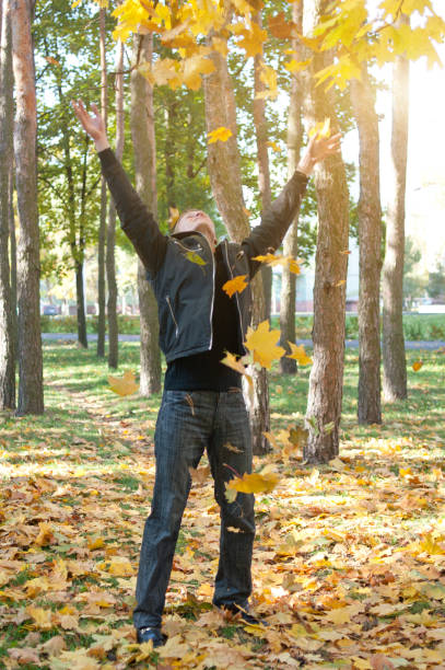 istock Young man throwing leaves in the air 155068056