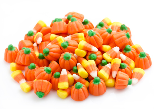 Halloween candy on a black background. coffee corn and sazar skull.Halloween holiday background with jack o lantern pumpkin, candy corn and decorations.Top view.Flat lay. Place for text.