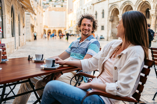 Young couple drinking coffee in a sidewalk café in Dubrovnik, Croatia.