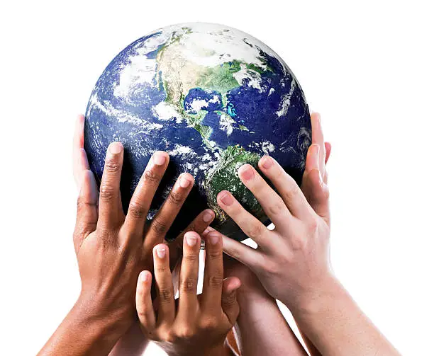 Photo of Many environmentally aware hands gently supporting the Earth.