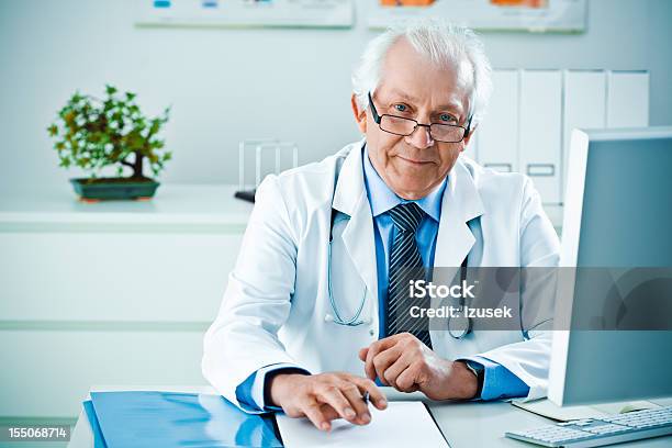 Masculino Médico Em Seu Escritório - Fotografias de stock e mais imagens de 60-64 anos - 60-64 anos, Adulto, Adulto maduro