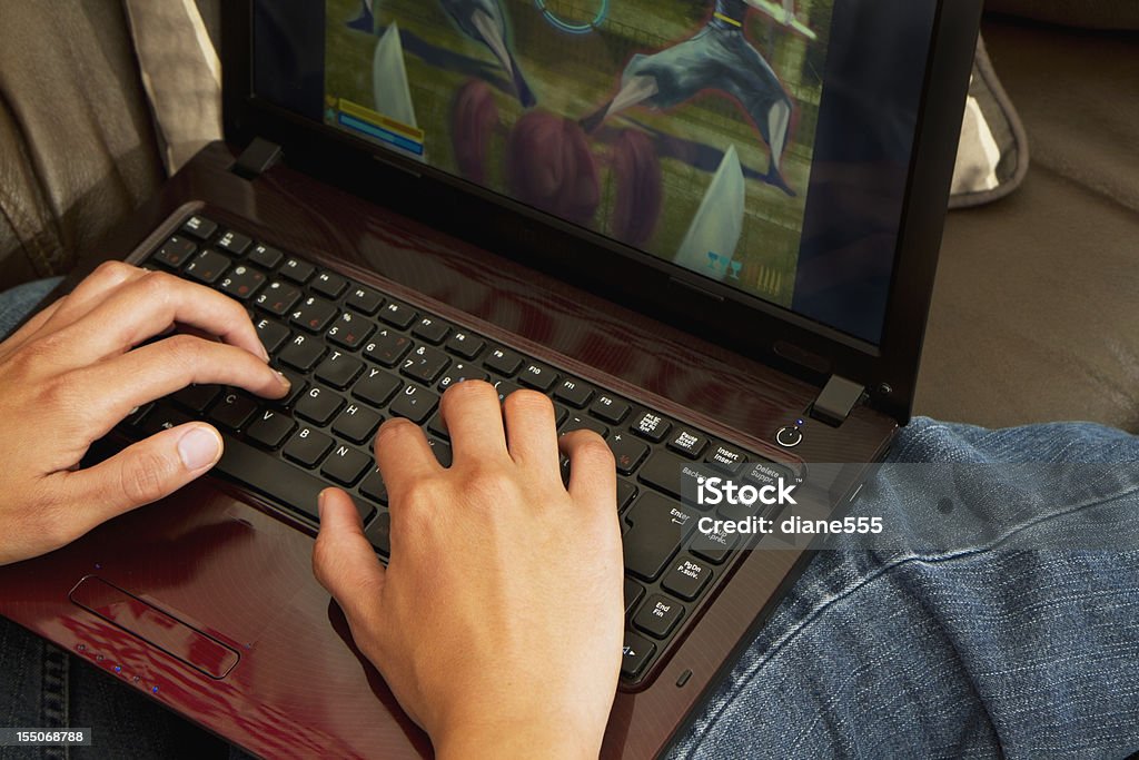 女性がコンピュータゲーム、ノートパソコン - カラー画像のロイヤリティフリーストックフォト