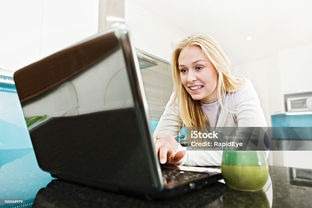 Bela Loira trabalha com laptop no balcão da cozinha Moderna - Royalty-free 20-29 Anos Foto de stock