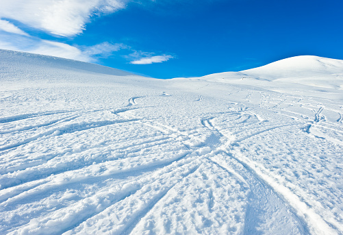 Various winding car tracks on the snow in winter, during the day