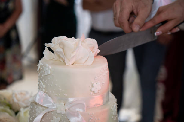 istock Wedding cake, hands and the knife, cutting 1550699530