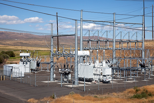 Top view of a high-voltage distribution substation. At the substation site, many insulating poles, busbars and switches are visible, which are visible from the elevation.