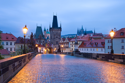 Wide-angle view of the famous Charles bridge in Prague, crowded with tourists and locals.
