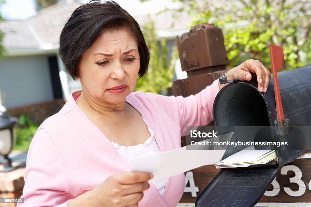 Preoccupato Senior donna ispanica Controllare la casella di posta - Foto stock royalty-free di Cassetta delle lettere