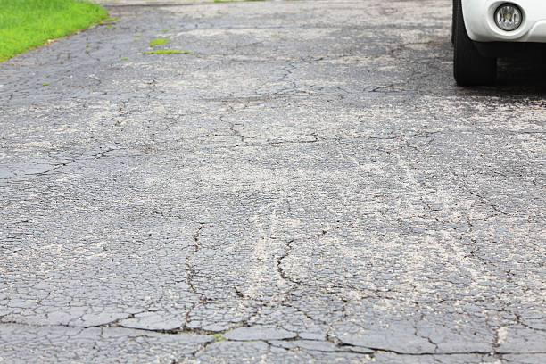 istock Cracked asphalt driveway with car parked 155071241