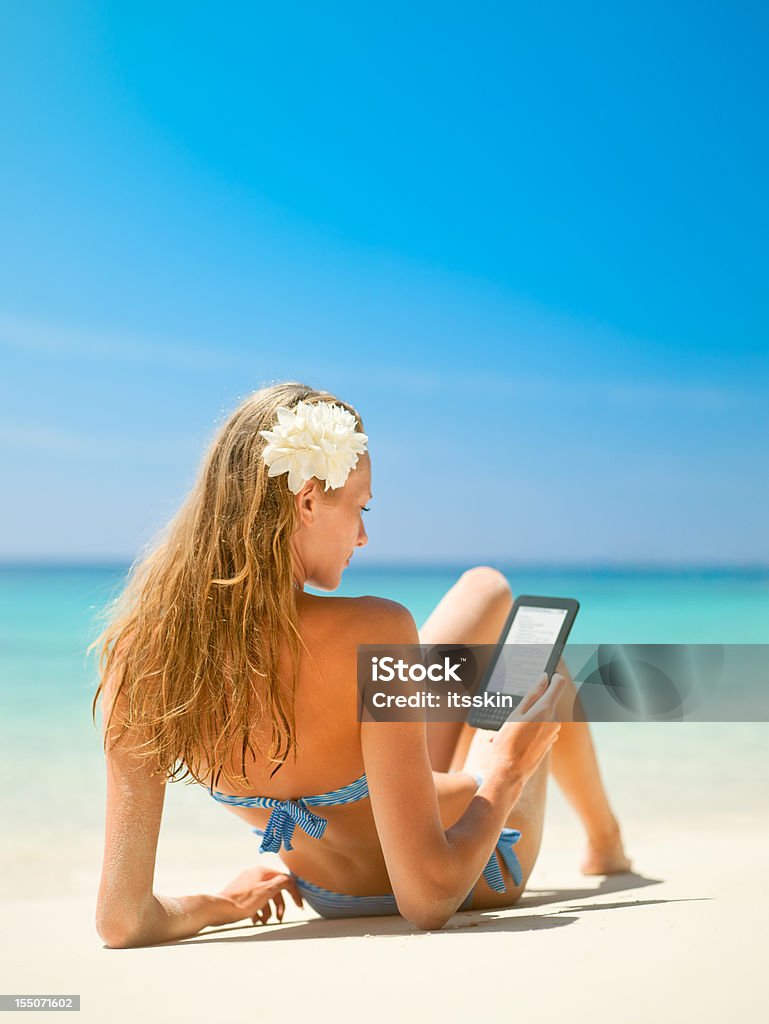 Belle femme lisant un e-book sur la plage - Photo de Femmes libre de droits