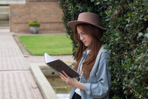 istock beautiful young student woman reading a book in a university library 1550718372