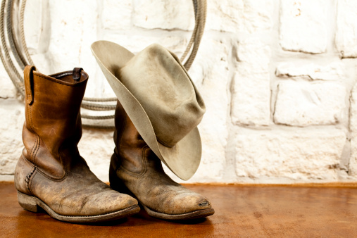 Botas de vaquero y sombrero. Arenisca fondo de Austin photo