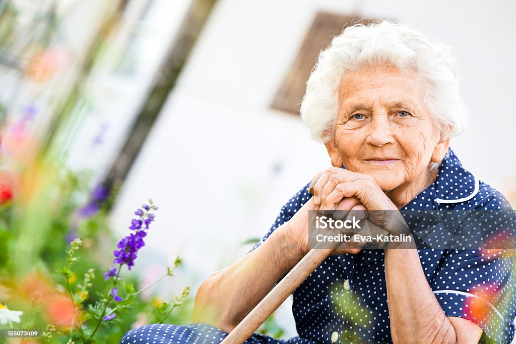 Summer afternoon Peaceful elderly lady relaxing in front of her house 80-89 Years Stock Photo