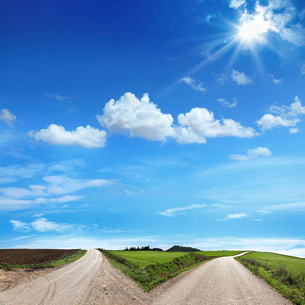 bifurcation - winding road sunlight field cultivated land photos et images de collection