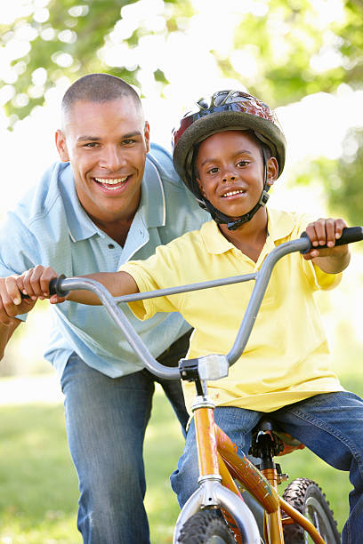 istock Father Teaching Son To Ride Bike In Park 155074507