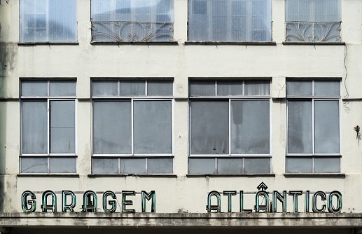 Detail view of closed-up and abandoned public car park with classic design neon sign in central Porto in Portugal