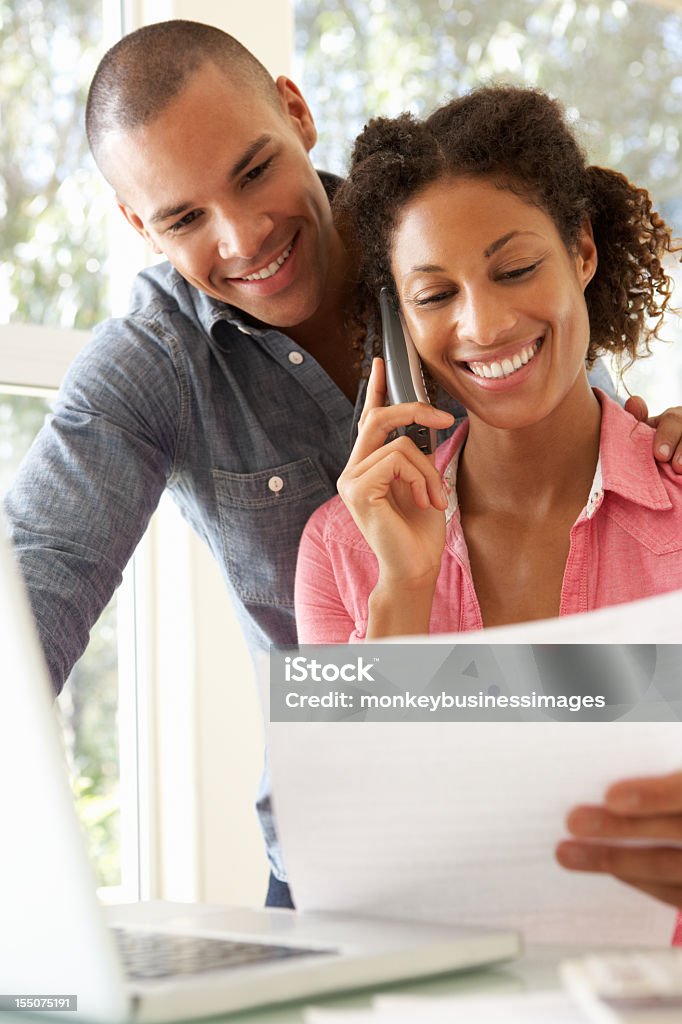 Jeune Couple à l'aide d'ordinateur portable à la maison - Photo de Tous types de couple libre de droits