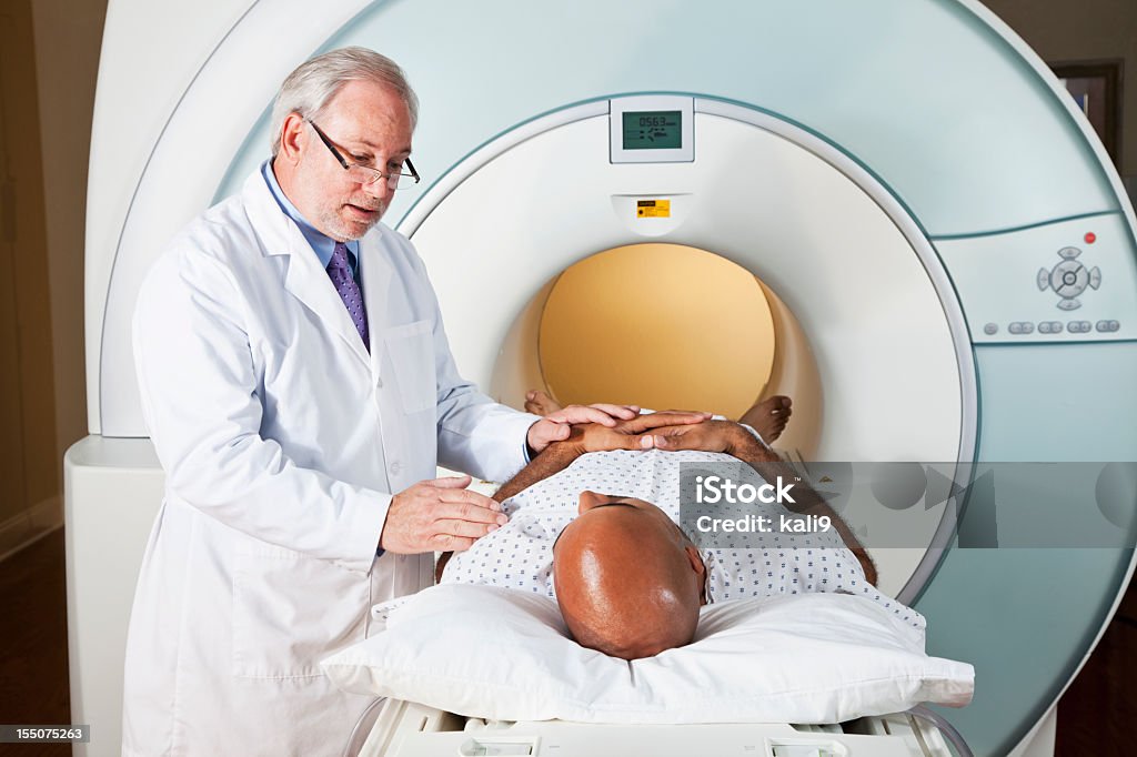 Medico parlando con paziente ottenere RMI - Foto stock royalty-free di RMN