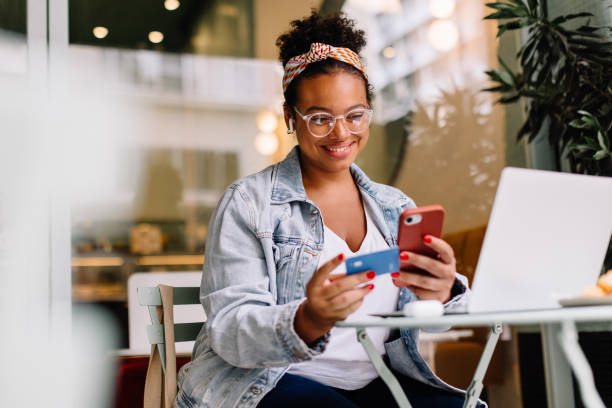 istock Woman smiling and using mobile for online payment 1550754806