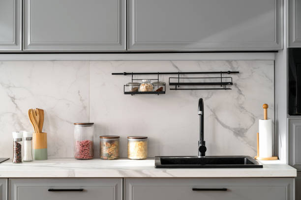 Marble countertop with black sink near light ceramic wall