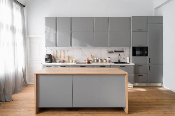 istock Bright kitchen interior with gray furniture and big dining table 1550757718