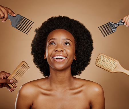 Hair, comb and brush selection with a black woman in studio on a brown background for beauty or cosmetics. Salon, afro or haircare with hands at a hairdresser and an attractive young female model