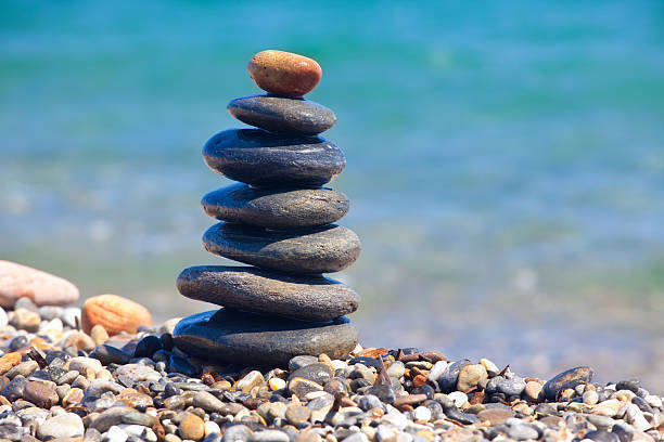 Stack of sea stones with defocused beach at background. High resolution 42Mp outdoors digital capture taken with SONY A7rII and Zeiss Batis 40mm F2.0 CF lens