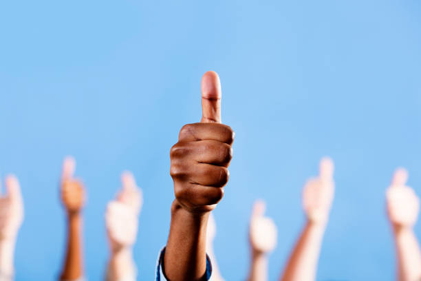 istock Thumbs up! Male African-American hand gestures, others in background 155076607