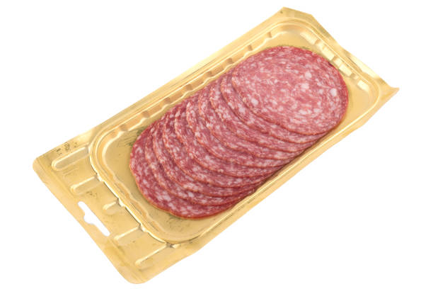 Sliced delicious sausage servelat on a plastic package isolated on a white background. Copy space.