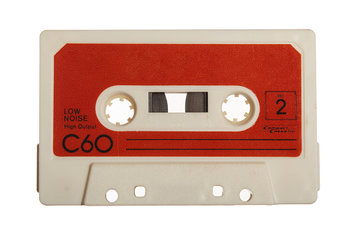 Four Old Audio Cassettes on a Wooden Planks Background closeup