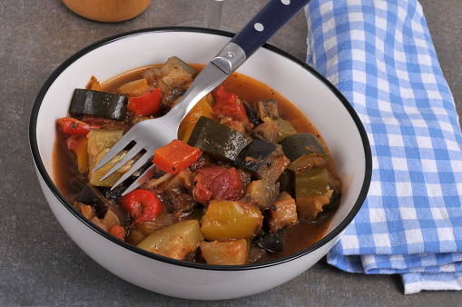 Plate of homemade ratatouille with a fork and a napkin