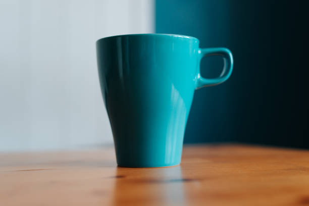 istock Close-up of a blue mug on a wooden table indoors, selective focus on object 1550803546