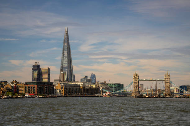 London, England, United Kingdom - July 23, 2022. London's urban skyline from the River Thames with popular tourist attractions, including modern glass skyscrapers,  traditional English buildings, famous London bridges, London market, the docklands and fishing as well as tour boats. No recognizable people.