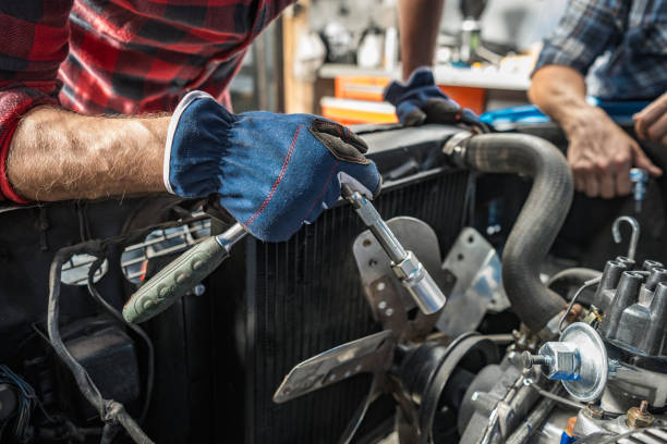 Professional Caucasian Mechanic Taking Care of a Classic Car Engine stock photo