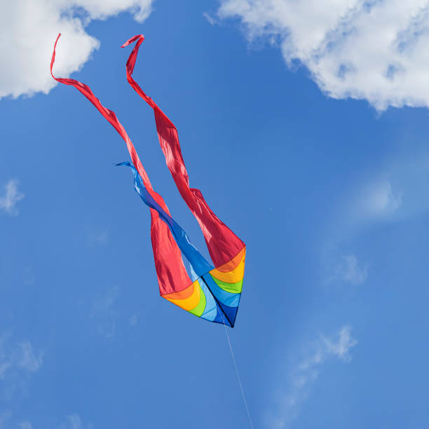 istock Colorful flying kite flying in sky with clouds 1550906672