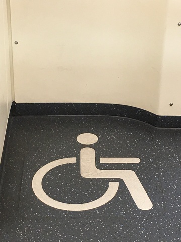 The symbol on the ground indicates that this is a disabled area, located at the public transport station.
