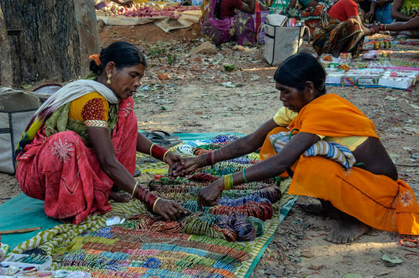 The tribal women wearing glass bangles in a local fair in Baster. Baster,Chhattisgarh, the tribal women   wearing colorful glass bangles in a rural market in an afternoon, the bangles are a symbol of prosperity and wealth as per Indian culture.It's also treated as fashion. india indigenous culture indian culture women stock pictures, royalty-free photos & images