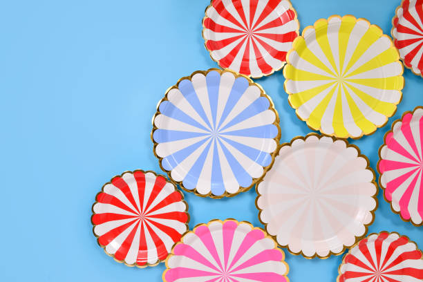 Colorful striped paper party plates on blue background