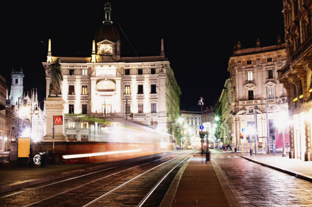 Milan, Italy, March 23, 2024: Historic street in Milan with ornate residential facades, parked cars and active traffic at the intersection, editorial image