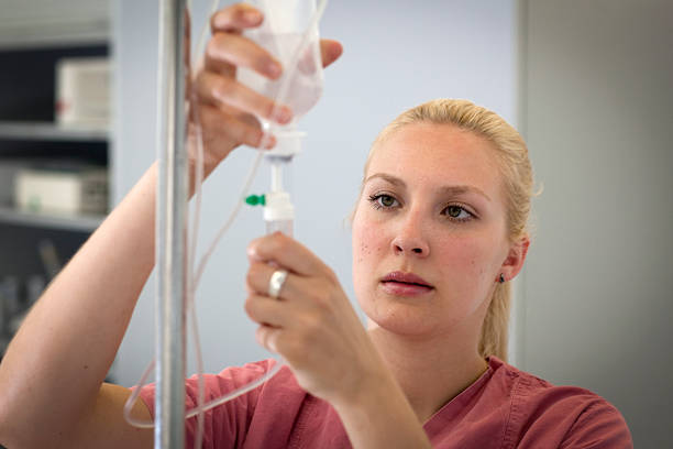female blond nurse is preparing an infusion stock photo