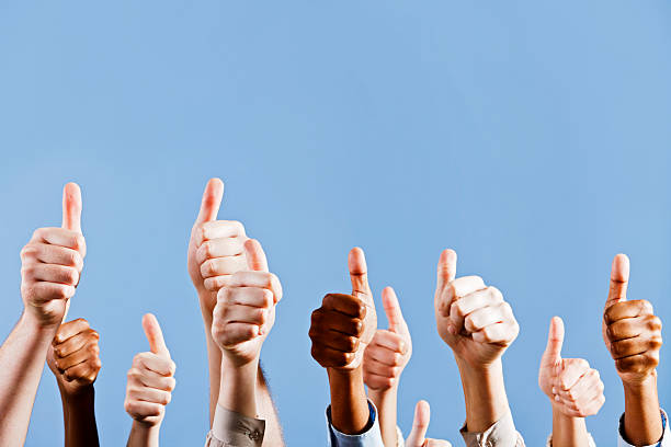 istock Many hands give approving thumbs up against blue background 155095288