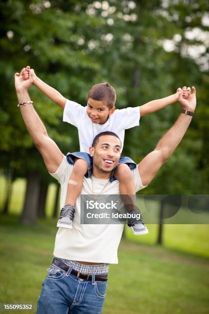 Foto de Pai Feliz Carregando O Filho Em Seus Ombros Ao Ar Livre e mais fotos de stock de Filho