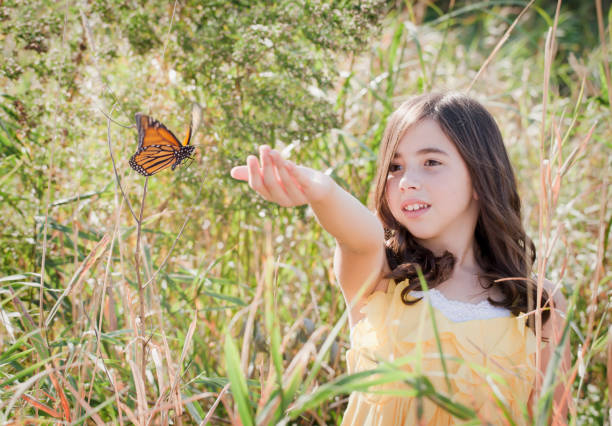 istock Girl in a Field with Monarch Butterfly 155095750