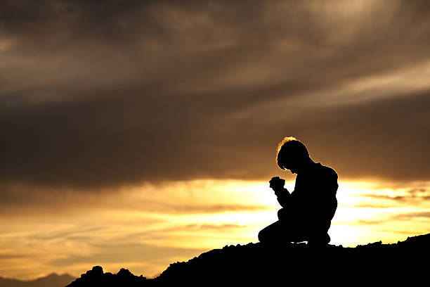 istock Silhouette of Young Caucasian Boy Praying 155095895