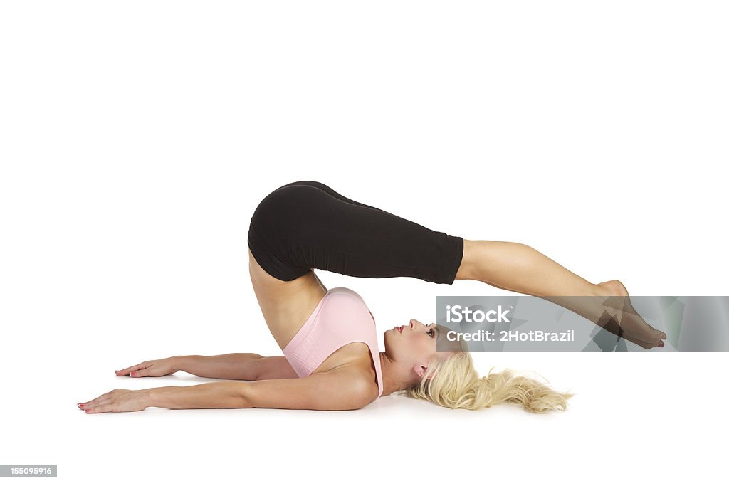 Young Woman Practicing Pilates Rollover - Isolated Young Woman Practicing Pilates-a rollover exercise. Isolated on white Health Club Stock Photo